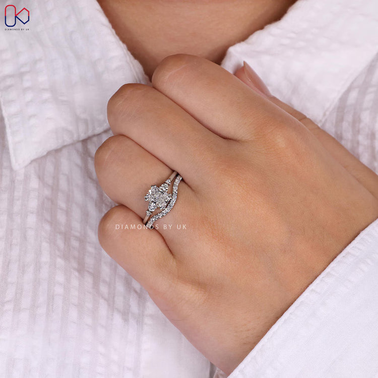 Radiant cut ring with round side stones and curved band.