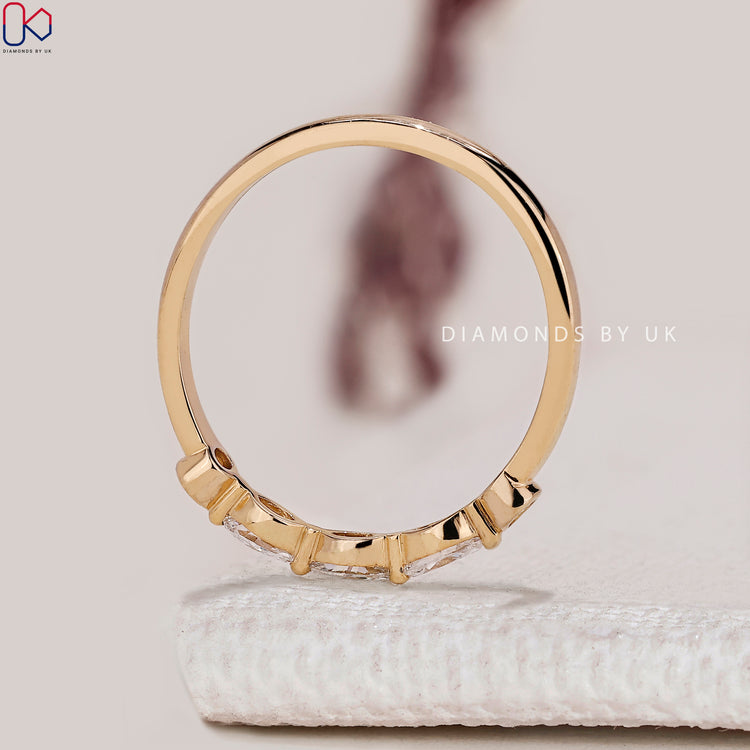 Marquise diamond band with round stones and shared prongs.

