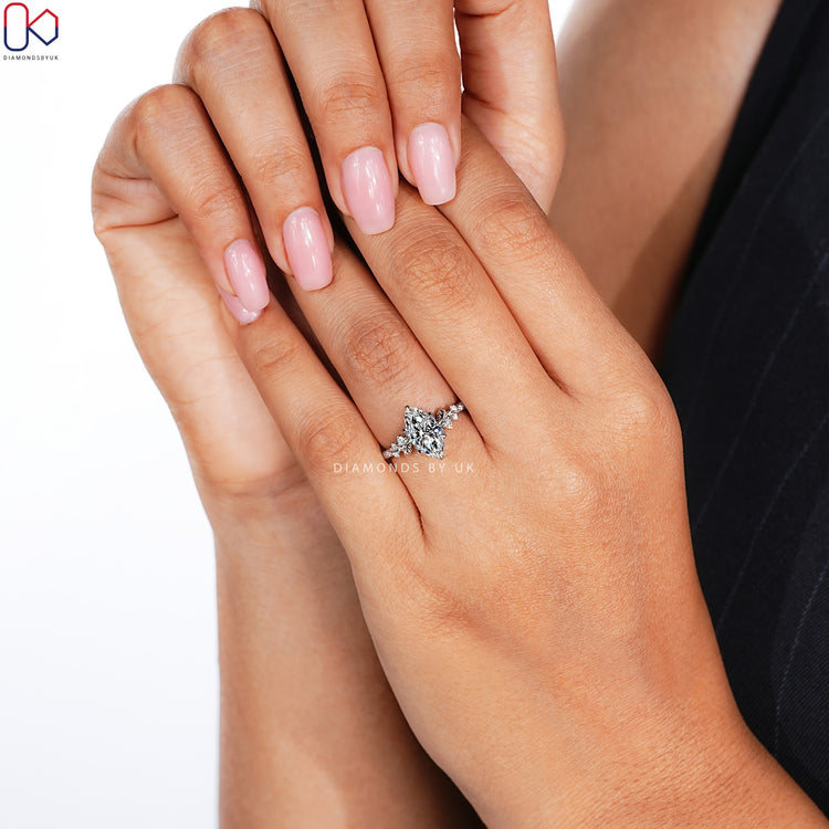 Marquise engagement ring with round diamond side stones.

