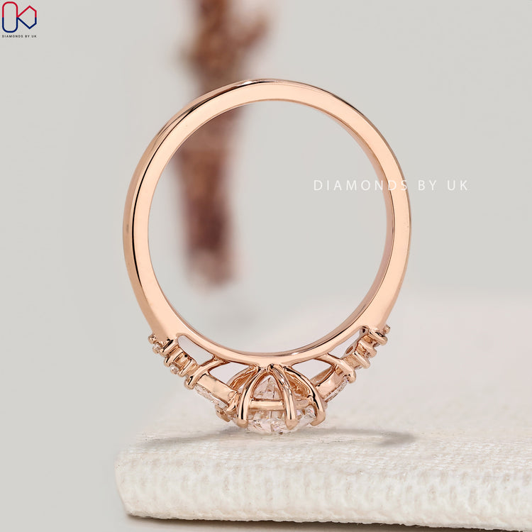 Oval diamond ring with round and pear side stones.
