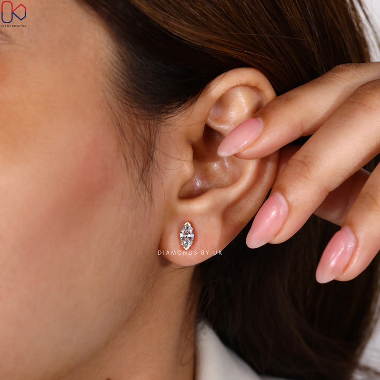 Solitaire marquise diamond earrings with V prongs.