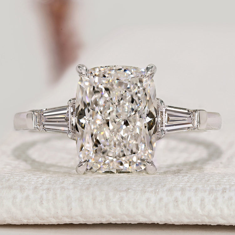 Cushion cut diamond ring with three stone style.
