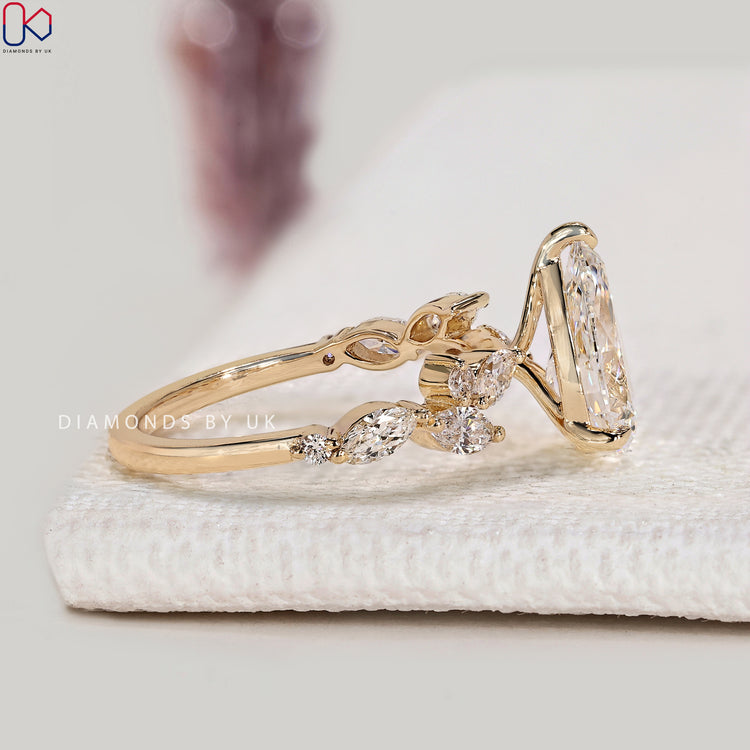 Lab grown pear diamond ring with round side stones.
