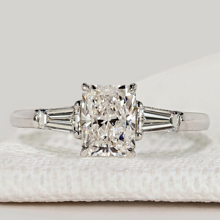 Pear diamond ring with three stone round side design.