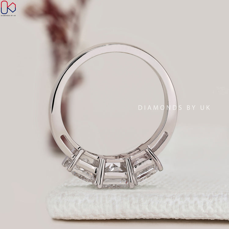 Princess cut ring with three stone design style.