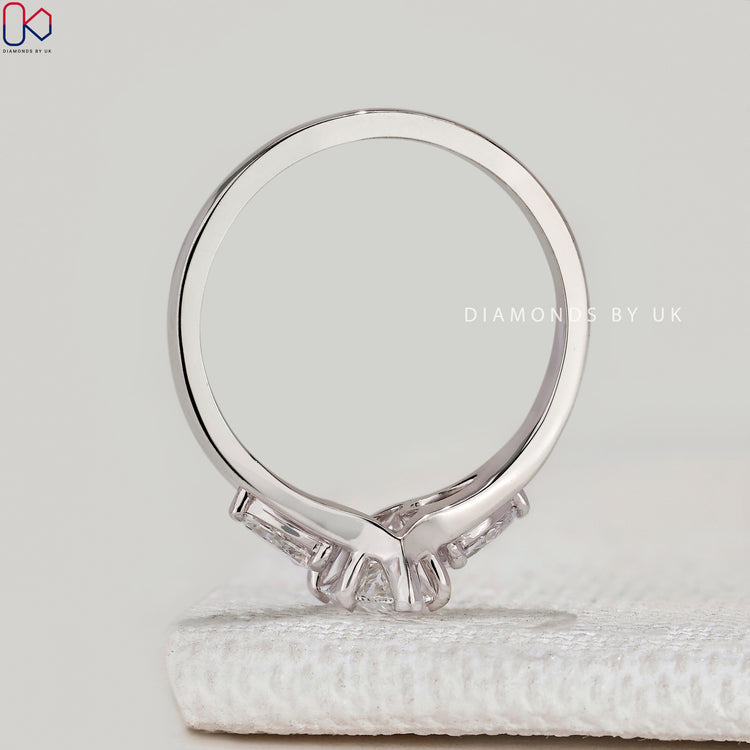 Marquise ring with pear side stones and split shank.