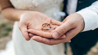 Bride holding groom's wedding band, representing traditional bride's responsibility